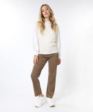 Load image into Gallery viewer, A model wearing brown pants and a white shirt, showcasing an elegant short sleeve sweater with a turtleneck and vintage-inspired shoulder pads.
