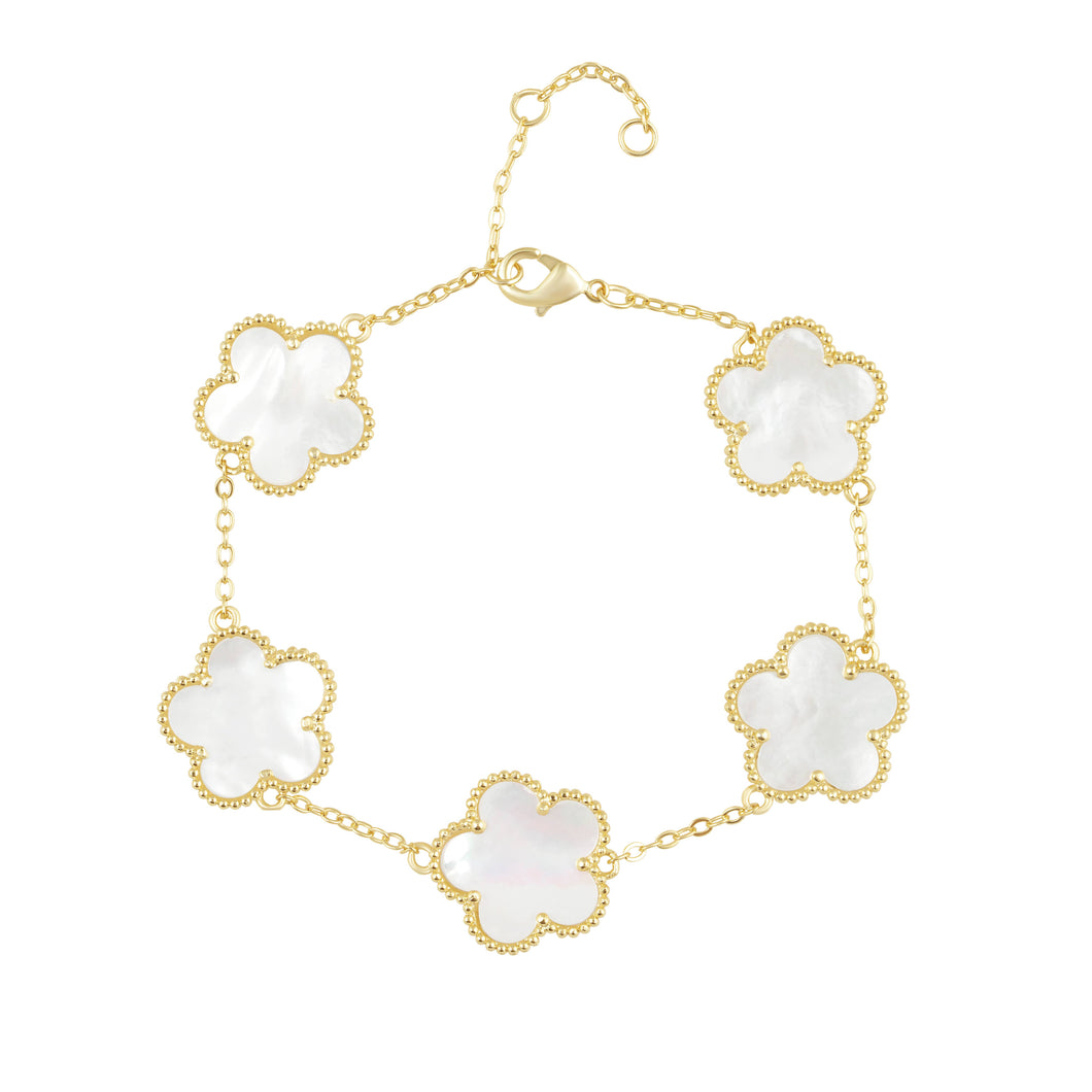 Gold bracelet with white clover-shaped mother of pearl charms.