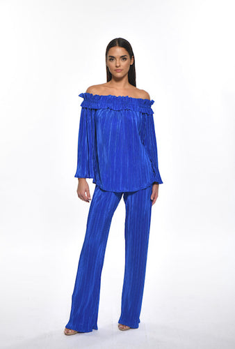 Fashionable model wearing the Julian Chang Rock the Villa blue off shoulder top paired with the Julian Chang Leslie Pant in Blue.