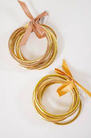 Glittery 5-row metal tube bracelet with herringbone design on faux leather bangle.