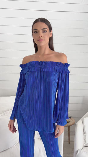 Stylish model donning blue off shoulder top & wide leg pants, paired with Rock the Villa Top by Julian Chang for a chic vibe.