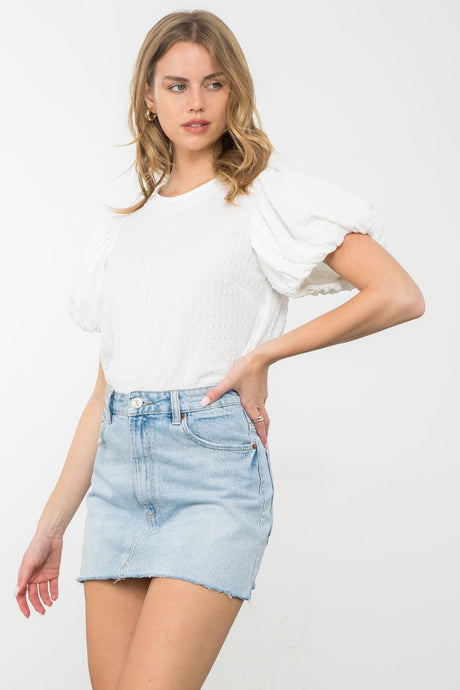 Elevate your style with the Cheshire Puff Sleeve Top from THML: Unleash your playful side with this textured top featuring delightful puff sleeves. Crafted with high-quality materials, it offers both comfort and a unique sense of style.