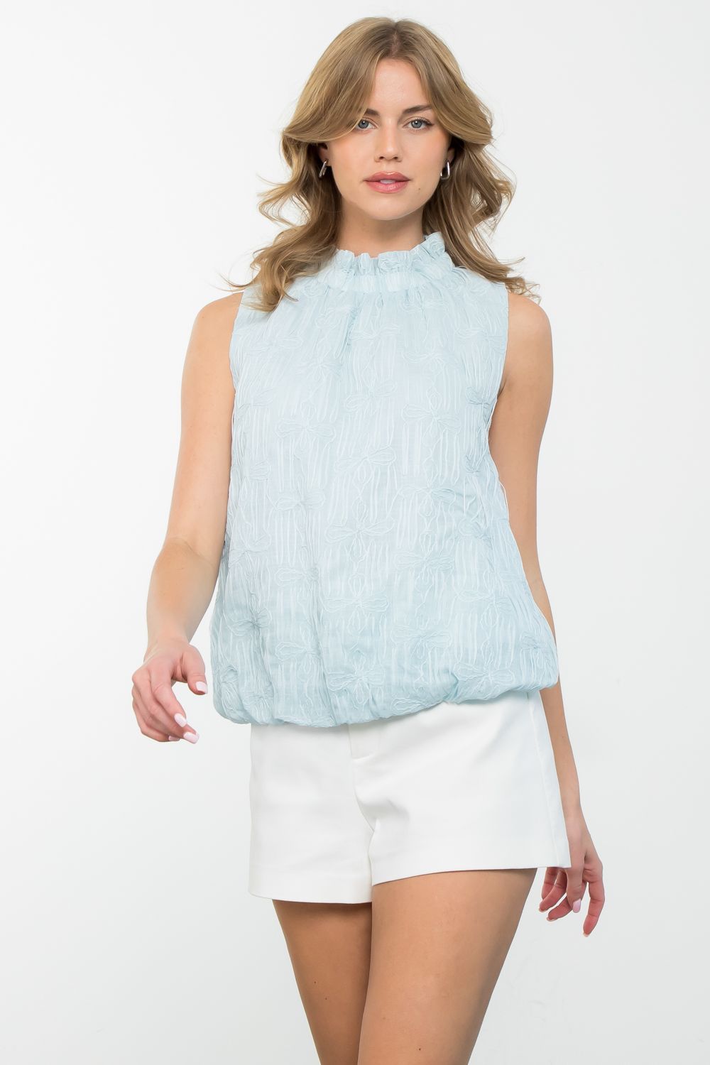 Stand out in style with THML's White Rabbit Textured Flower Top. This sleeveless top boasts a unique textured design and playful flower details, perfect for adding a touch of quirkiness to any outfit. Embrace your fun side with this must-have!