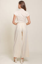 Load image into Gallery viewer, A woman wearing cream top and wide leg pants from Line and Dot. Luxurious Ecru hue. Classic yet modern design. Comfortable fit and exquisite style.
