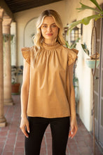 Load image into Gallery viewer, Tan top and black jeans on a model, highlighting the Lucy Ruffle Sleeve Top with ruffle sleeves and tie back detailing in soft corduroy material.
