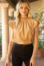 Load image into Gallery viewer, A model wearing a tan top and black jeans, showcasing the Lucy Ruffle Sleeve Top with trendy ruffle sleeves and cute tie back detailing in soft corduroy material.
