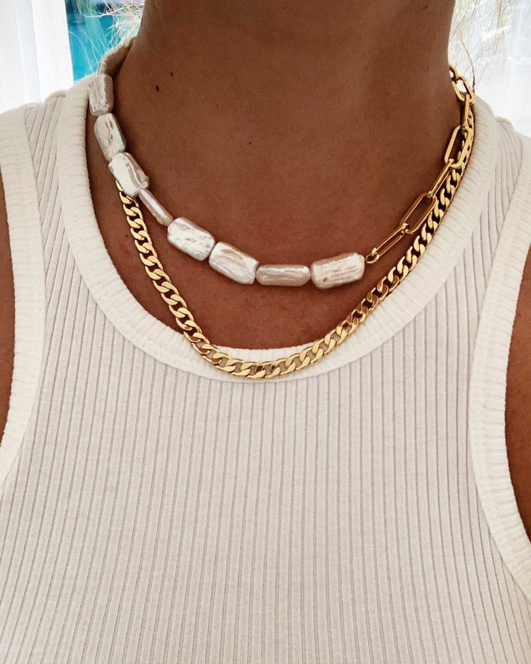 Elevate your style with this trendy half pearl half chain necklace. Featuring rectangular freshwater pearls and a fashionable paper clip chain, it can be worn as a choker or a short necklace. Versatile and timeless, it's the perfect accessory for any occasion.