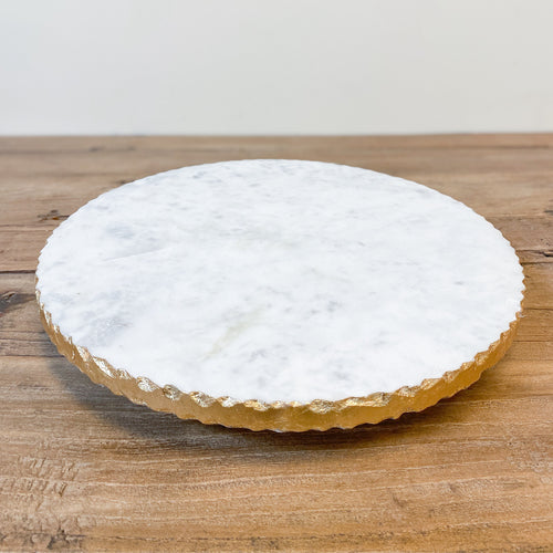 White marble trivet with gold foil raw edge rim. Perfect for your dinner table or island.