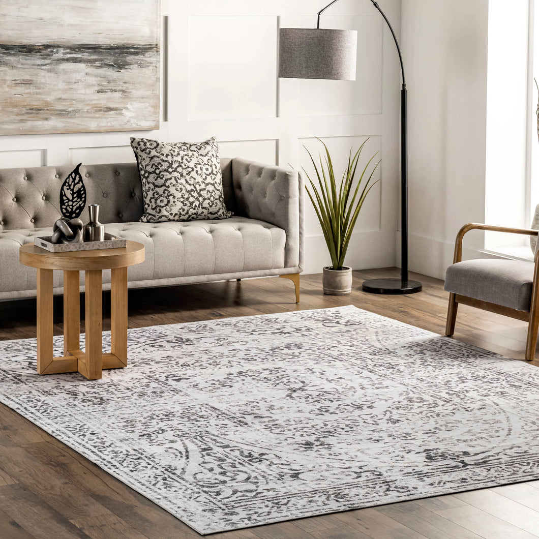 Transitional vintage rug in a living room with a sofa and chair, adds warmth and style to any decor. Machine made from 100% polyester, washable, and made in China.