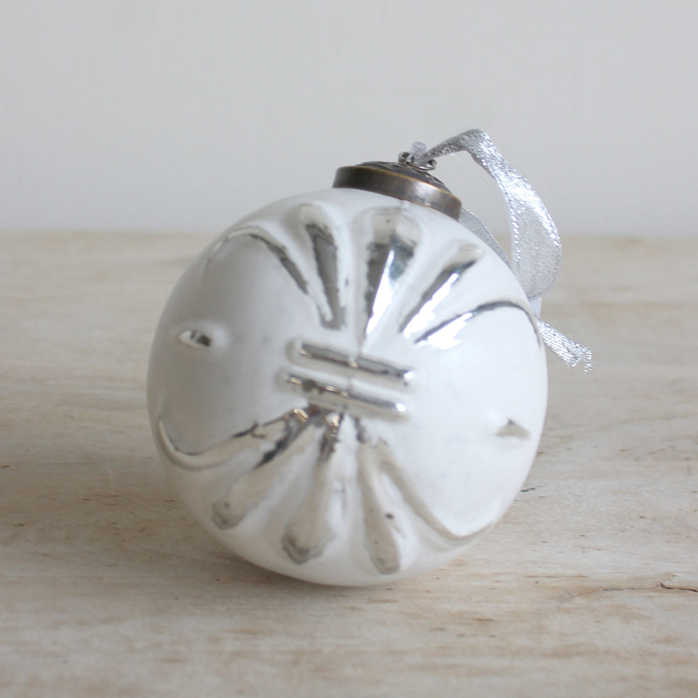 A delicate glass ornament featuring a beautiful fleur design.