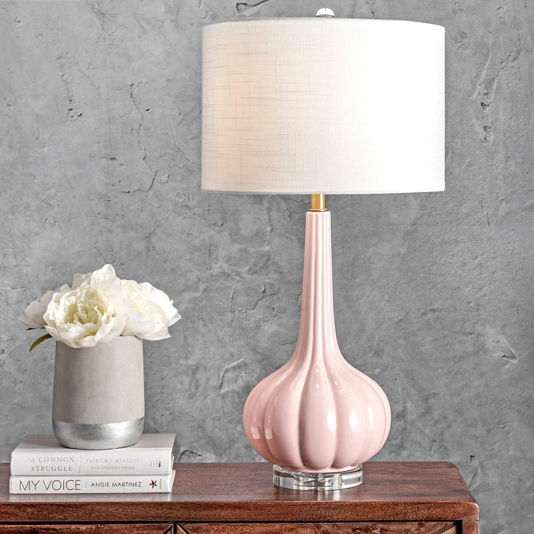 A modern pink table lamp with a white shade, perfect for illuminating any area in your bedroom or living room.