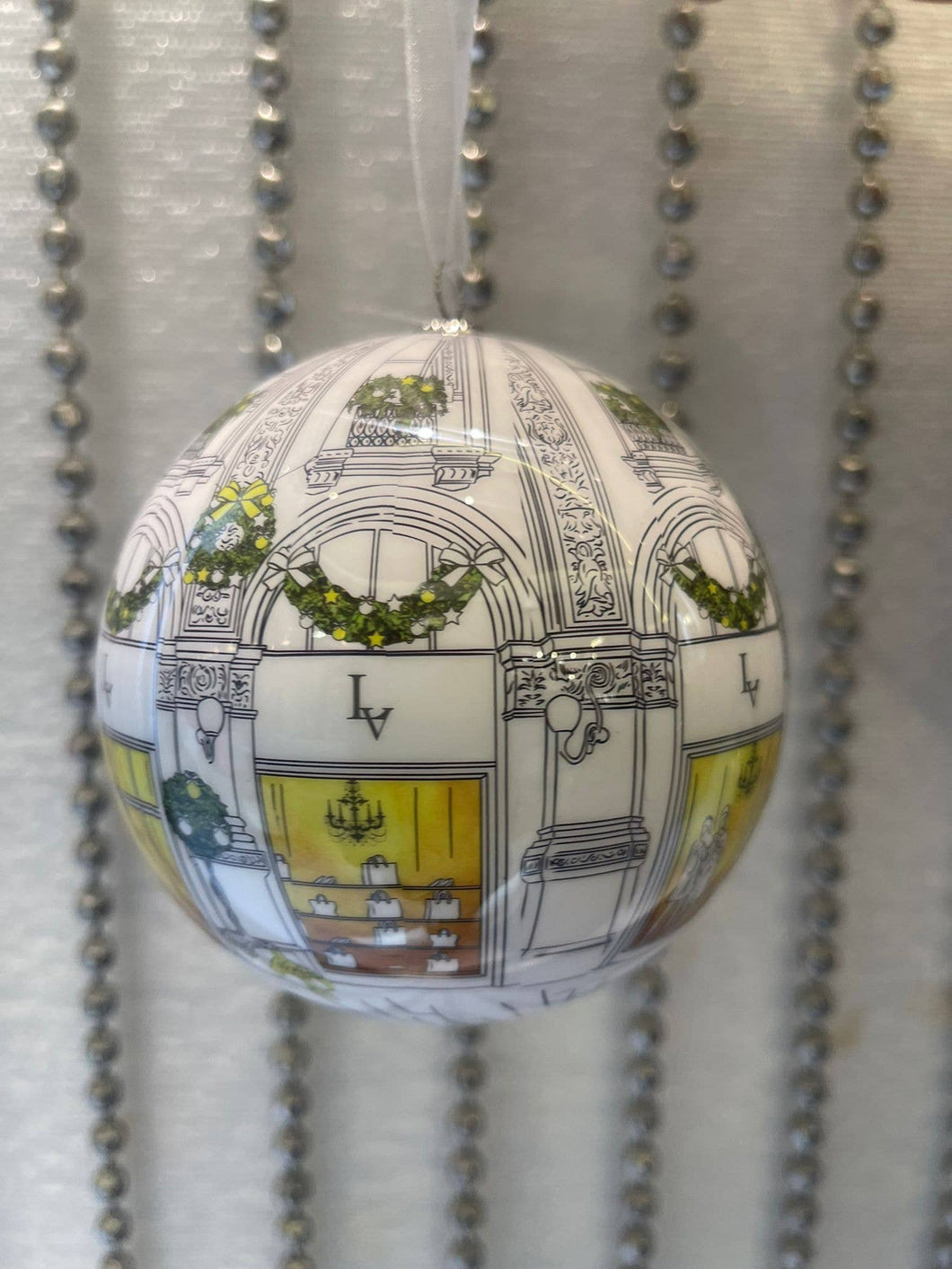 White Decoupage Baubles inspired by Louis Vuitton for Christmas. Shiny, beautifully illustrated, hung on white organza ribbon.