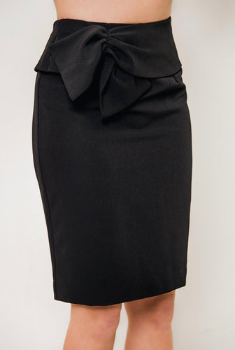 An elegant woman donning a black skirt with a bow, featuring the stylish Black Bow Waist Skirt by Posh Couture.