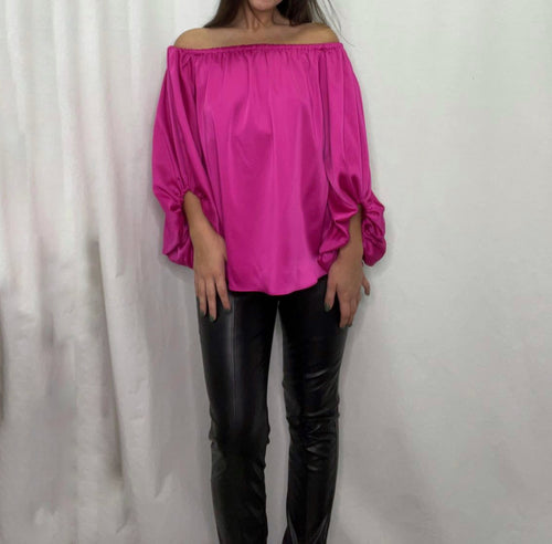 Flat front off-shoulder blouse with elastic rouching on sides and back. Long sleeves with ruffle detail on wrist.