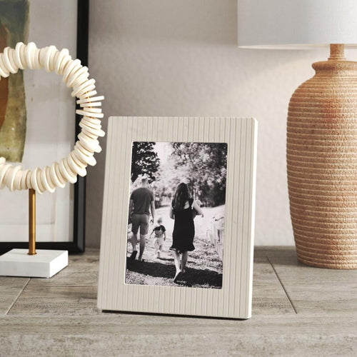 A sophisticated marble frame with a textured and refined grooved design, perfect for displaying memories on built-ins or a coffee table.